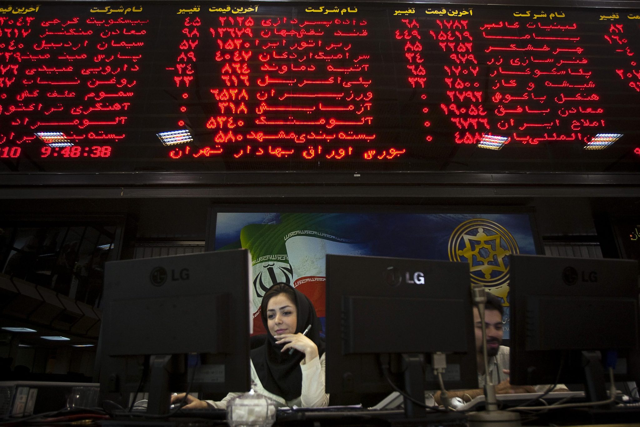 An Iranian official works at her desk in the main hall of the Tehran Stock Exchange